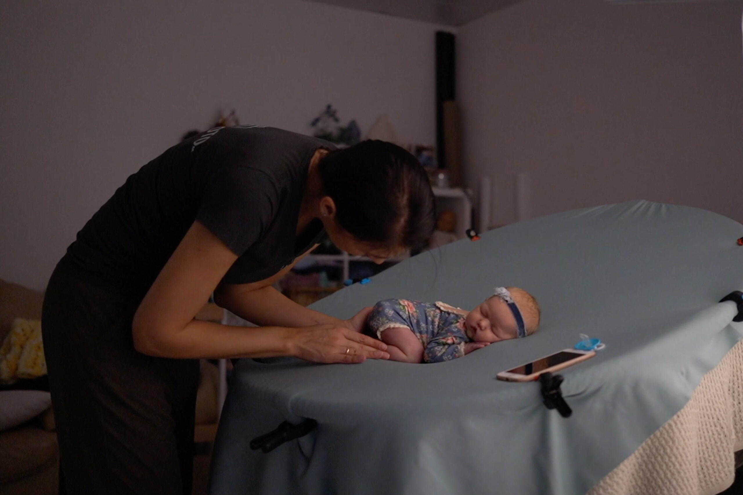 Online Course in Newborn Photography: Master Skills, Earn More! *self-paced 2 Online Course in Newborn Photography behind-the-scenes showing a photographer safely posing a newborn on a posing table during a real session