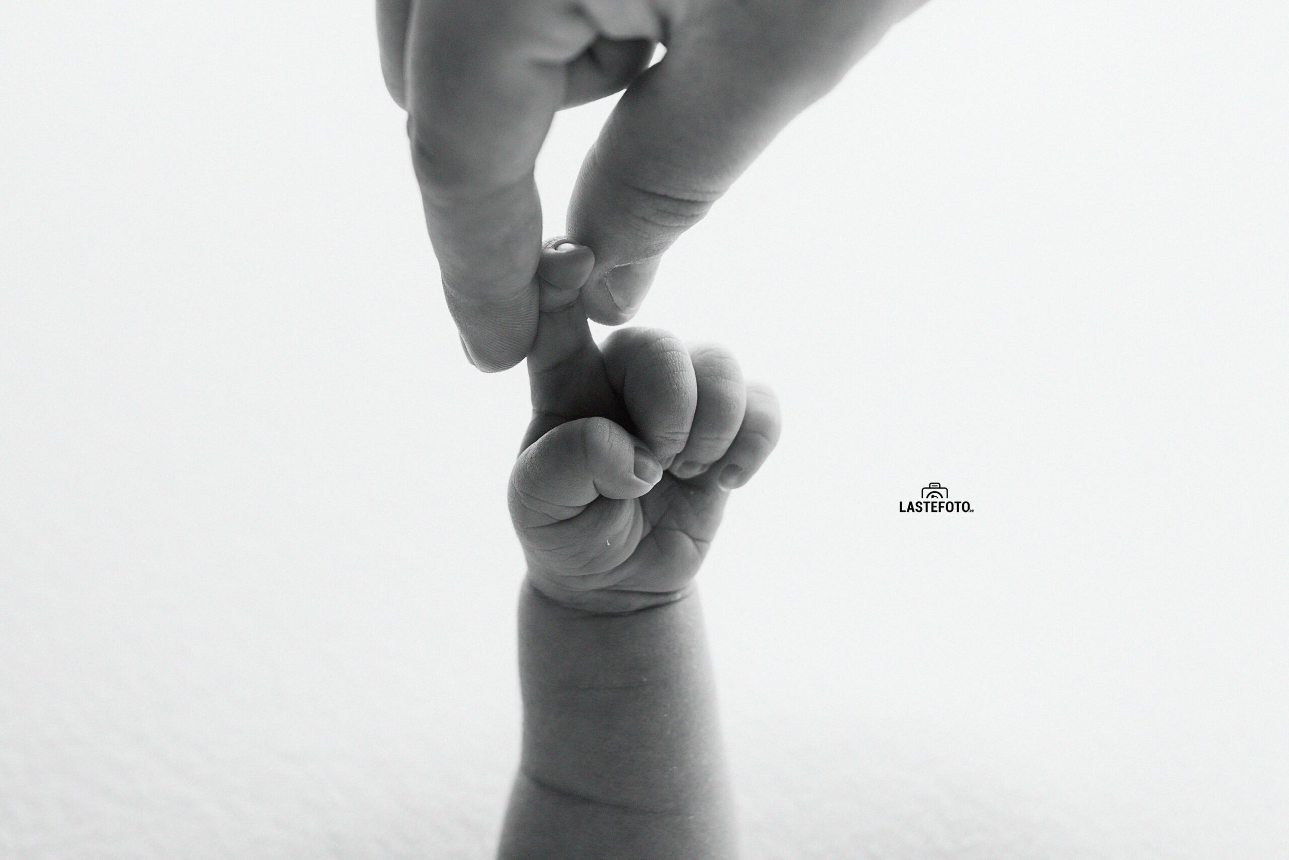 Vastsündinu pildistamise koolitus – vastsündinu hoiab mustvalgel fotol sõrmega ema kätt
