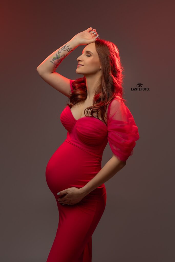 When to Do a Maternity Photoshoot: The Best Timing and 7 Things Most People Don’t Talk About 6 When to do a maternity photoshoot — studio profile portrait of a pregnant woman in a red dress with soft lighting