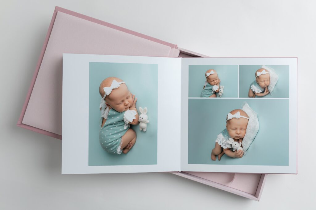 Fotoraamat teie pere looga - raamat, mida tahaks ikka ja jälle lehitseda 6 Fotoraamat on avatud lehel, kus on fotod magavast vastsündinust helesinisel taustal; kõrval on roosa kinkekarp.